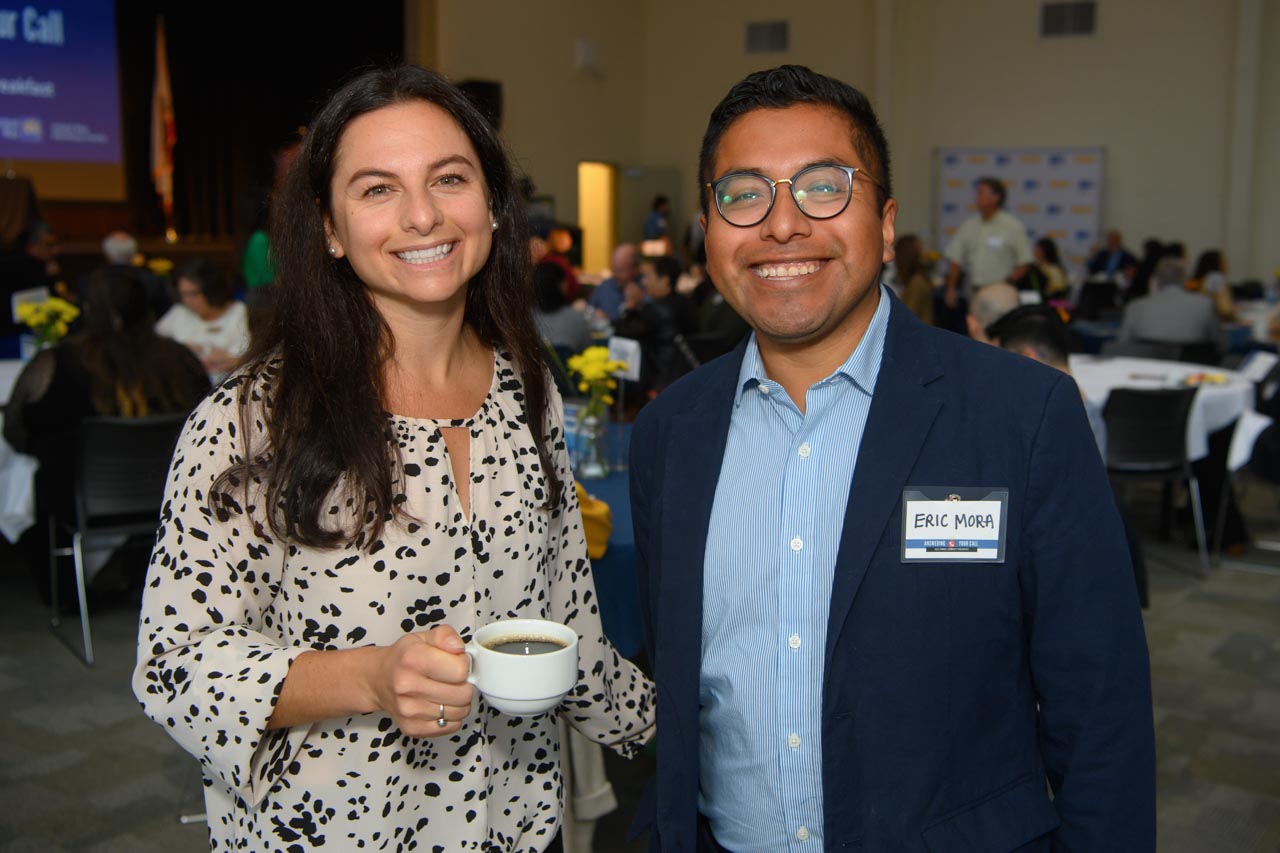 Two attendees, one holding a coffee