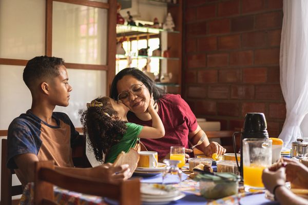 A family is sitting at a table eating breakfast together.