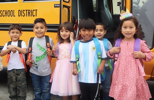 Stuff the Bus 2022 Kids in Front of a Bus with their backpacks