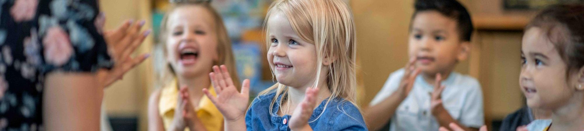 Kids in a classroom clapping