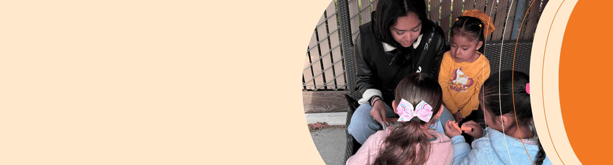 Young Woman sitting with three preschool children reading a book